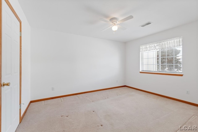 empty room with light carpet, ceiling fan, visible vents, and baseboards