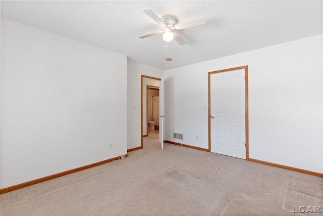 unfurnished room with visible vents, a ceiling fan, light colored carpet, and baseboards