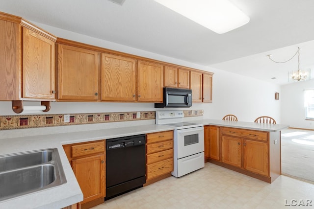 kitchen with light floors, a peninsula, light countertops, black appliances, and a notable chandelier