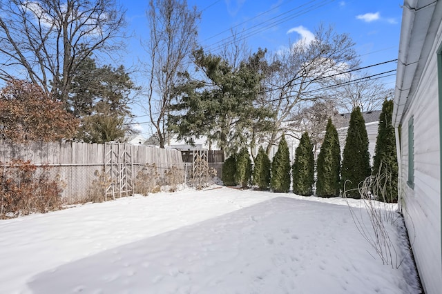 yard covered in snow featuring fence