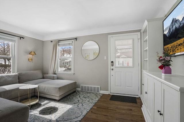 living room featuring baseboards, crown molding, visible vents, and dark wood-style flooring