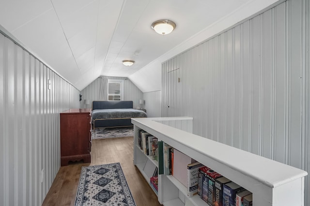 bedroom with vaulted ceiling and wood finished floors