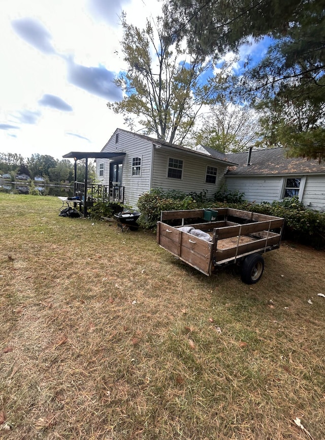 rear view of property with a yard and a vegetable garden