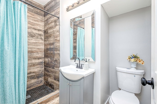 bathroom with a stall shower, vanity, and toilet