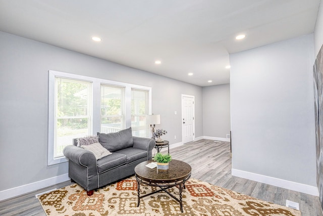 living area with light wood-style floors, baseboards, and recessed lighting