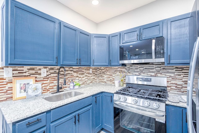 kitchen featuring a sink, appliances with stainless steel finishes, and blue cabinetry