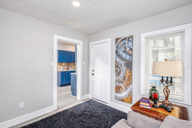 foyer with light wood finished floors and baseboards