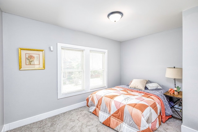 bedroom featuring light carpet and baseboards