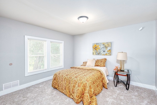 bedroom featuring baseboards, visible vents, and light colored carpet