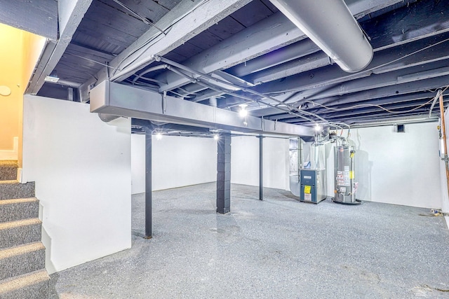 unfinished basement with gas water heater, stairway, and heating unit