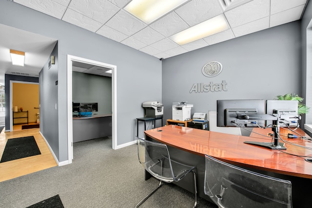 office featuring a paneled ceiling, visible vents, baseboards, and carpet