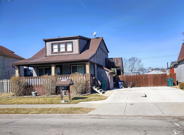 bungalow-style home featuring covered porch and fence