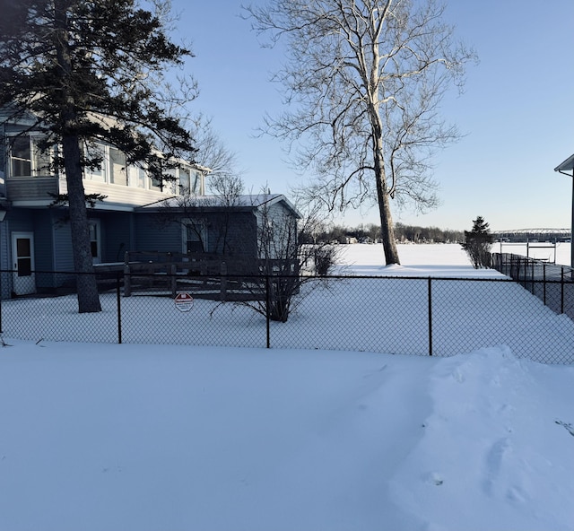 yard layered in snow featuring fence