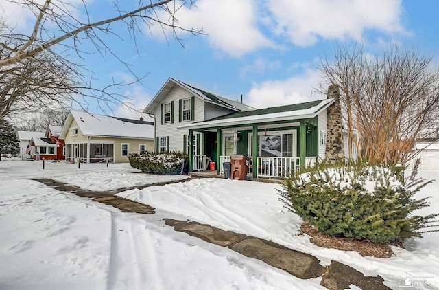 view of front of home with a chimney and a porch