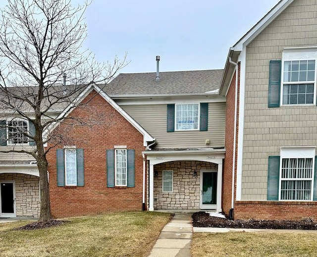 view of front of property featuring roof with shingles and a front yard