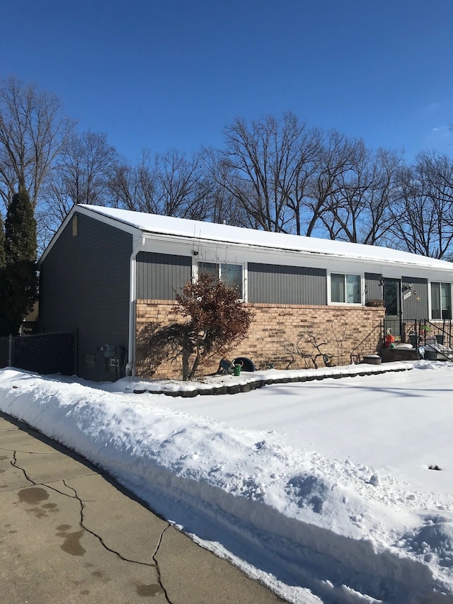 view of snow covered exterior featuring brick siding