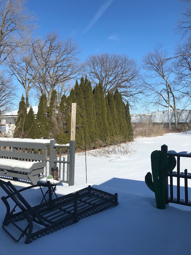 yard covered in snow featuring fence