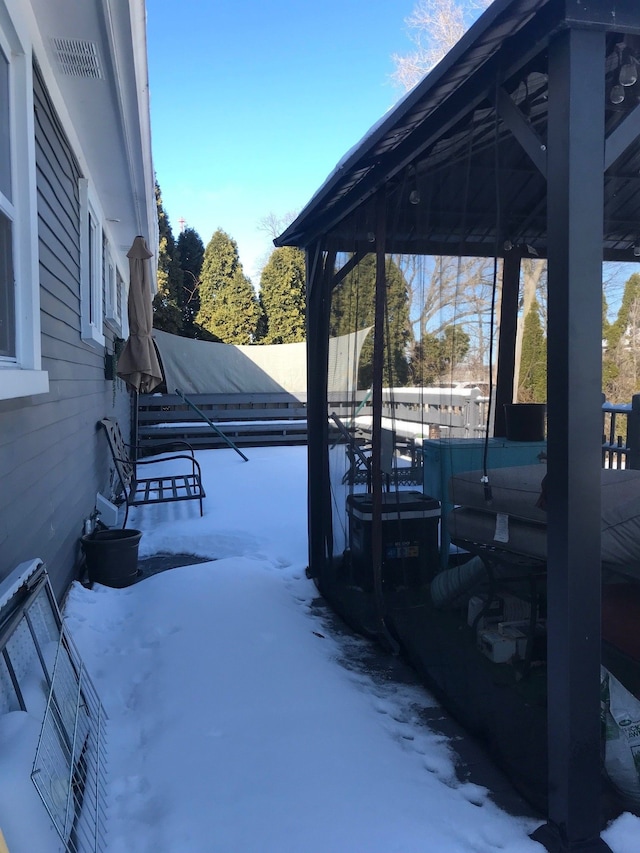 yard layered in snow with a gazebo