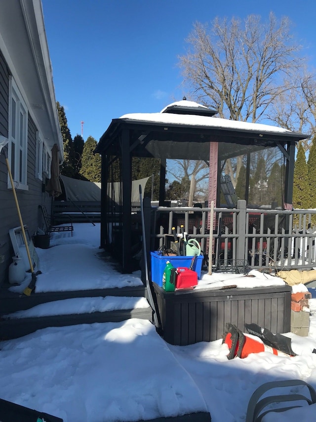 snow covered patio featuring a hot tub and a gazebo