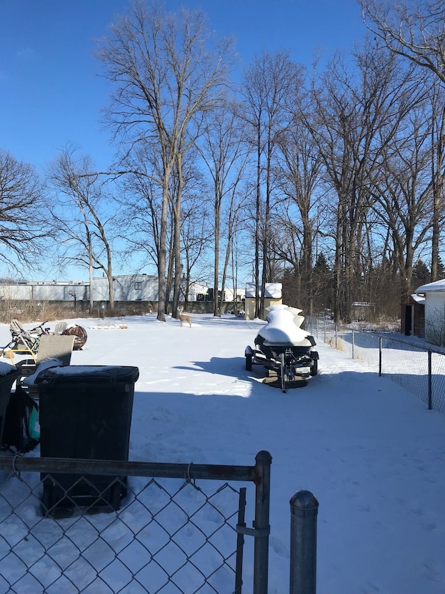 snowy yard featuring fence