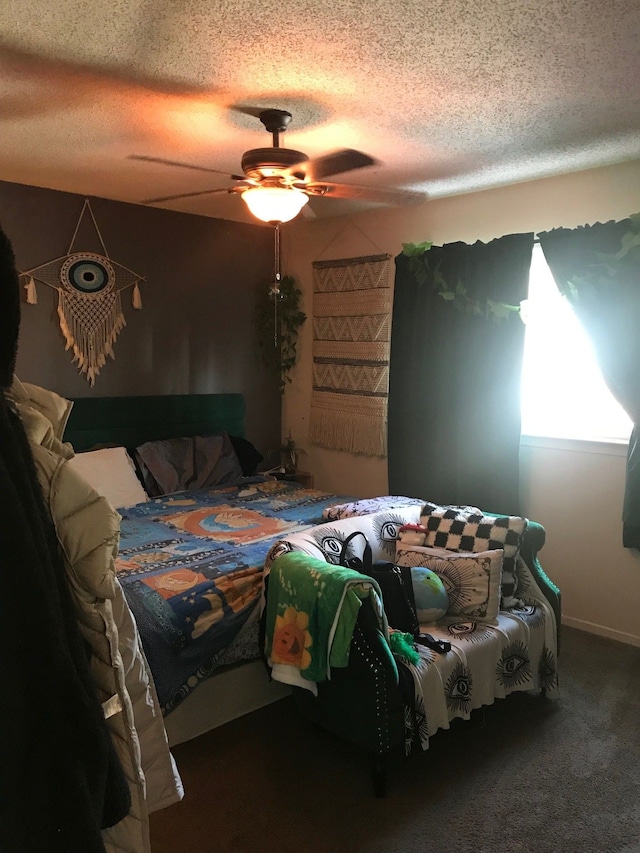 bedroom featuring ceiling fan, a textured ceiling, and dark carpet