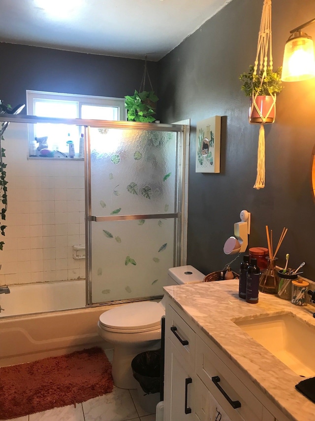 bathroom featuring vanity, toilet, and bath / shower combo with glass door