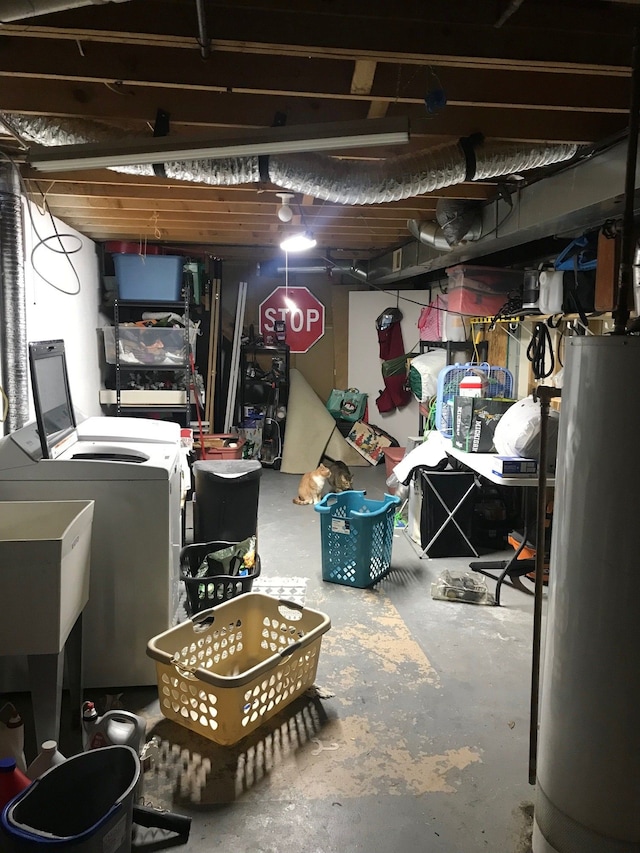 unfinished below grade area with washer and dryer, gas water heater, and a sink