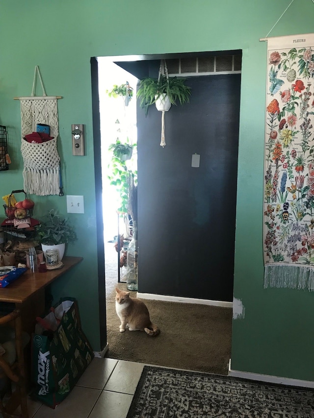 entryway with carpet floors, tile patterned flooring, and baseboards