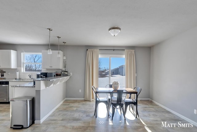 dining room featuring light wood-style flooring and baseboards