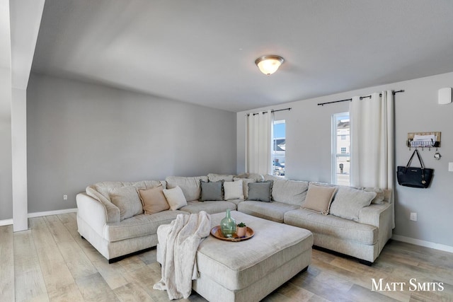 living area with light wood-style floors and baseboards