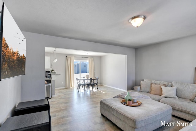 living area featuring light wood-type flooring and baseboards