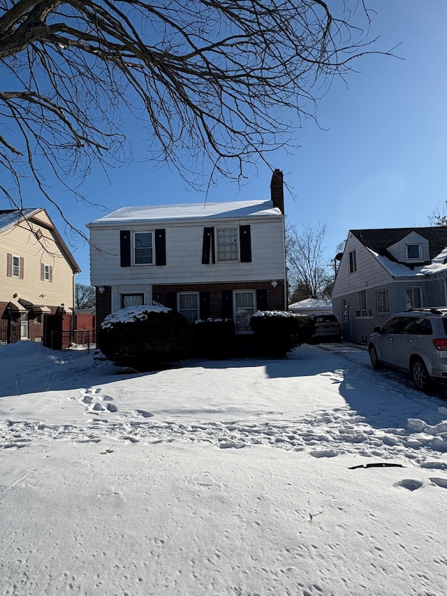 view of front of home with a chimney and fence