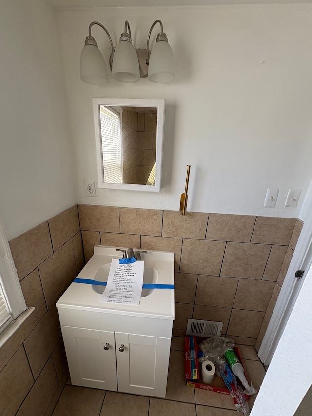 bathroom with a wainscoted wall, tile walls, and tile patterned floors