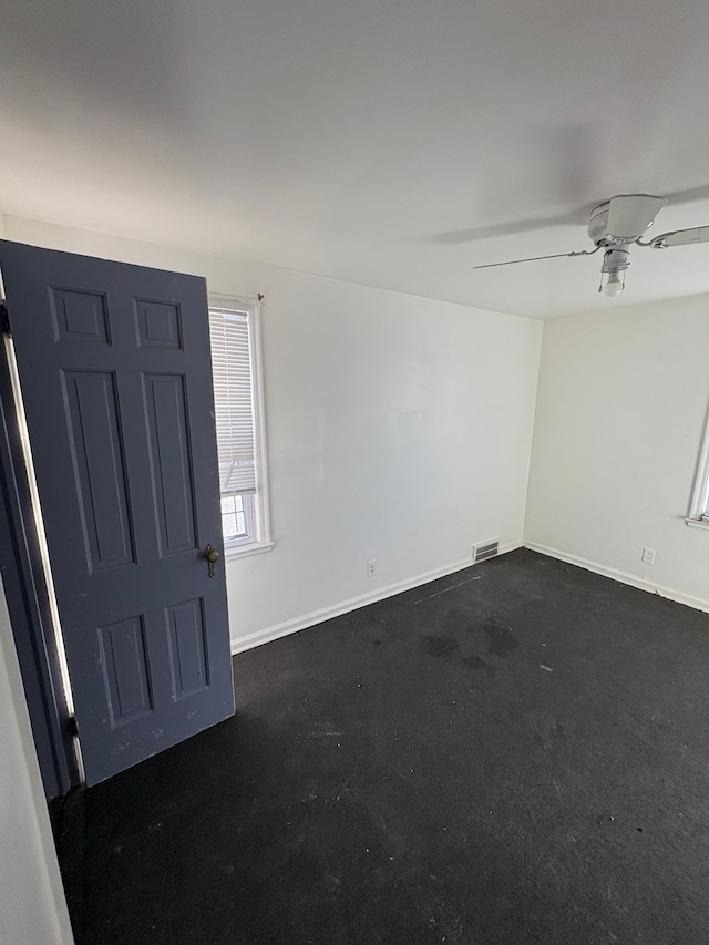 unfurnished room featuring a ceiling fan and baseboards