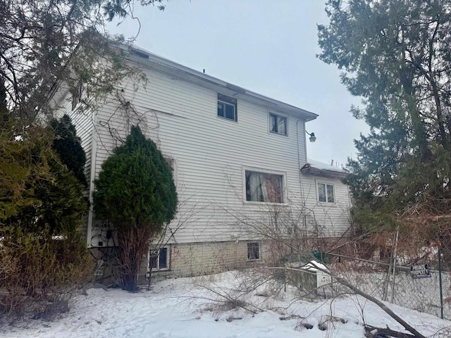 view of snow covered exterior featuring fence