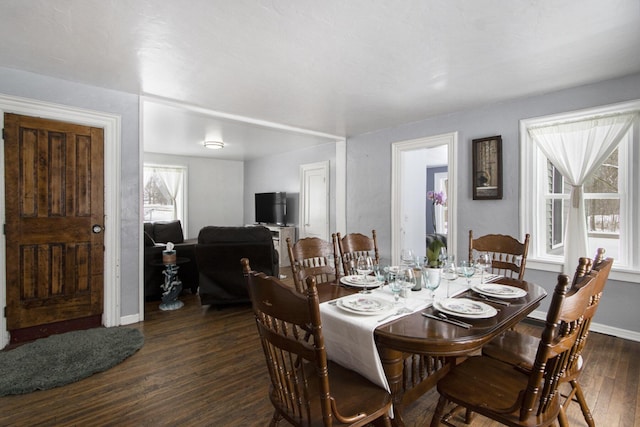 dining area featuring baseboards and dark wood finished floors