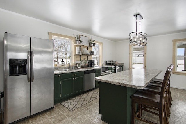 kitchen featuring a healthy amount of sunlight, a kitchen island, stainless steel appliances, and decorative light fixtures