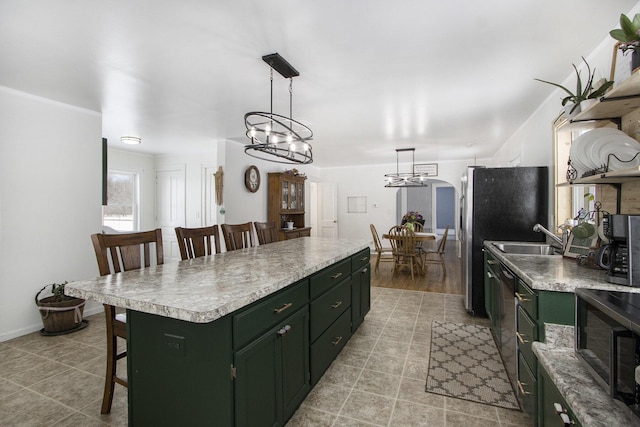 kitchen featuring a center island, stainless steel appliances, light countertops, pendant lighting, and a sink