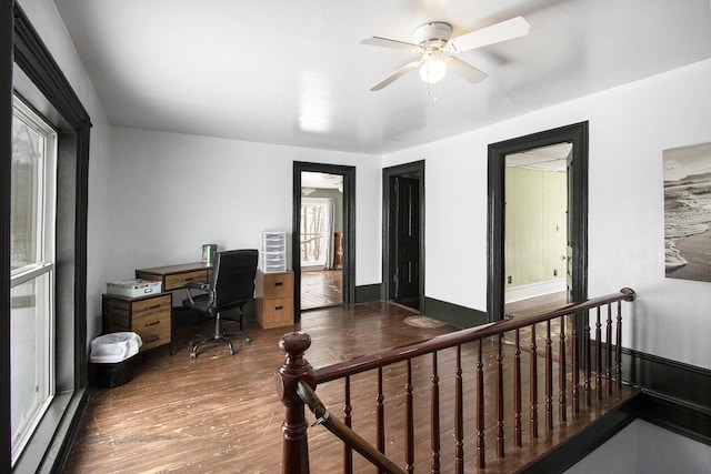 office area with dark wood-style flooring and baseboards