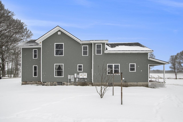 snow covered rear of property featuring a porch