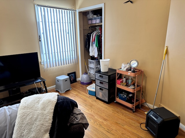 bedroom featuring baseboards, a closet, and light wood-style floors