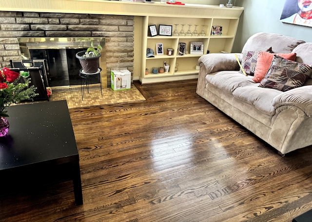 living room featuring dark wood-style floors and a brick fireplace