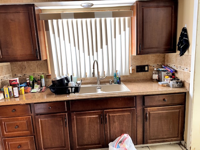 kitchen with tasteful backsplash, light countertops, and a sink