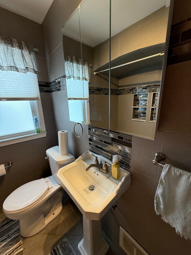 bathroom with tasteful backsplash, tile walls, and toilet