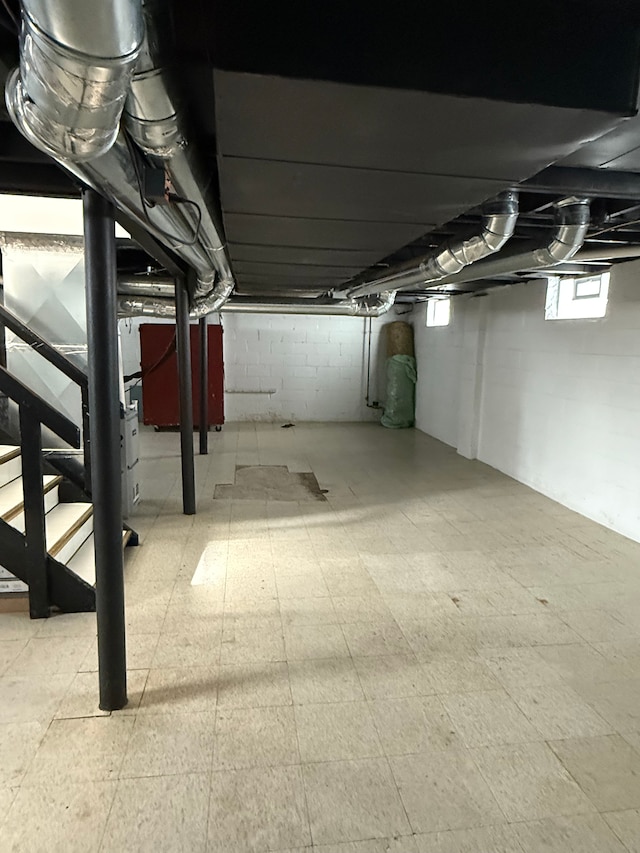 basement featuring stairway and tile patterned floors