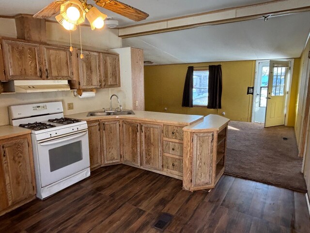 kitchen with white gas stove, under cabinet range hood, a peninsula, a sink, and light countertops