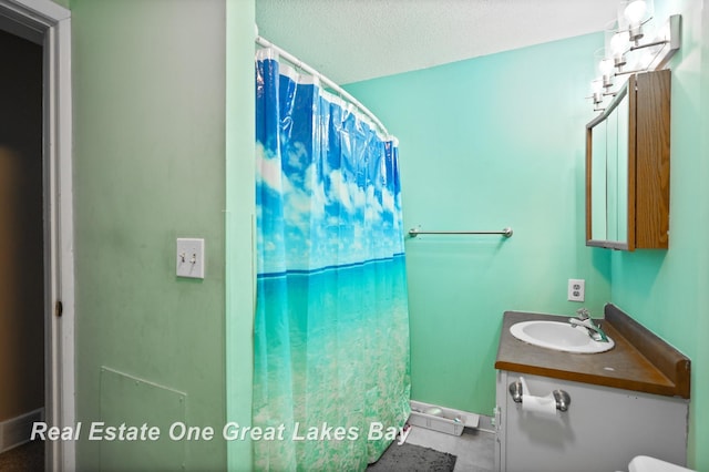 bathroom featuring a shower with shower curtain, a textured ceiling, and vanity