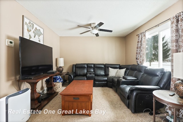 living area with a textured ceiling and ceiling fan