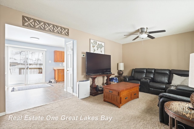 living area featuring a ceiling fan, light colored carpet, and baseboards