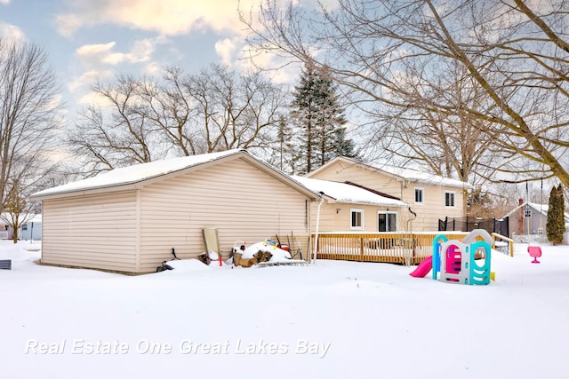 snow covered property with a deck